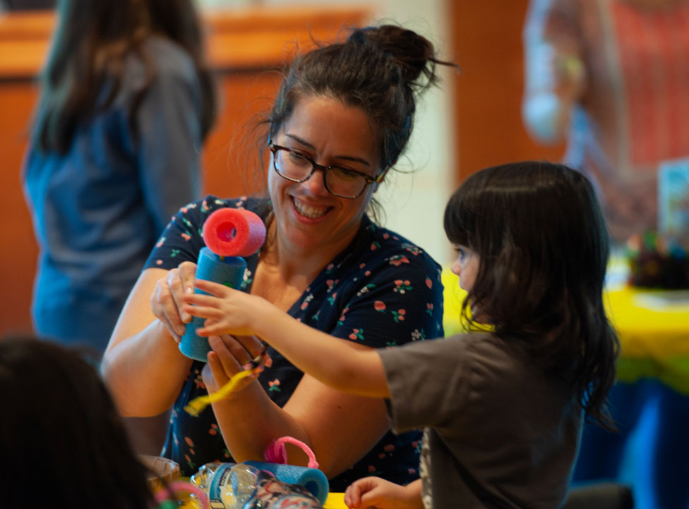 Person and child are building something together at a table